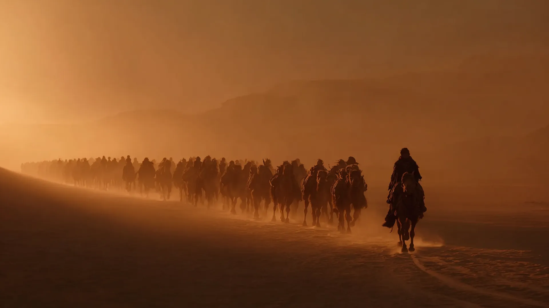 A vast caravan of laden camels stretching across the Arabian desert at dawn, with a lone horseback figure surveying the route from a ridge